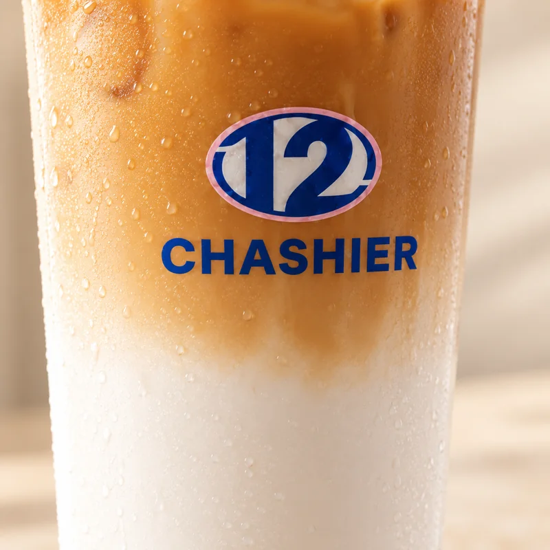 Primer plano de un iced latte de Chashier con la leche y el caramelo mezclándose.