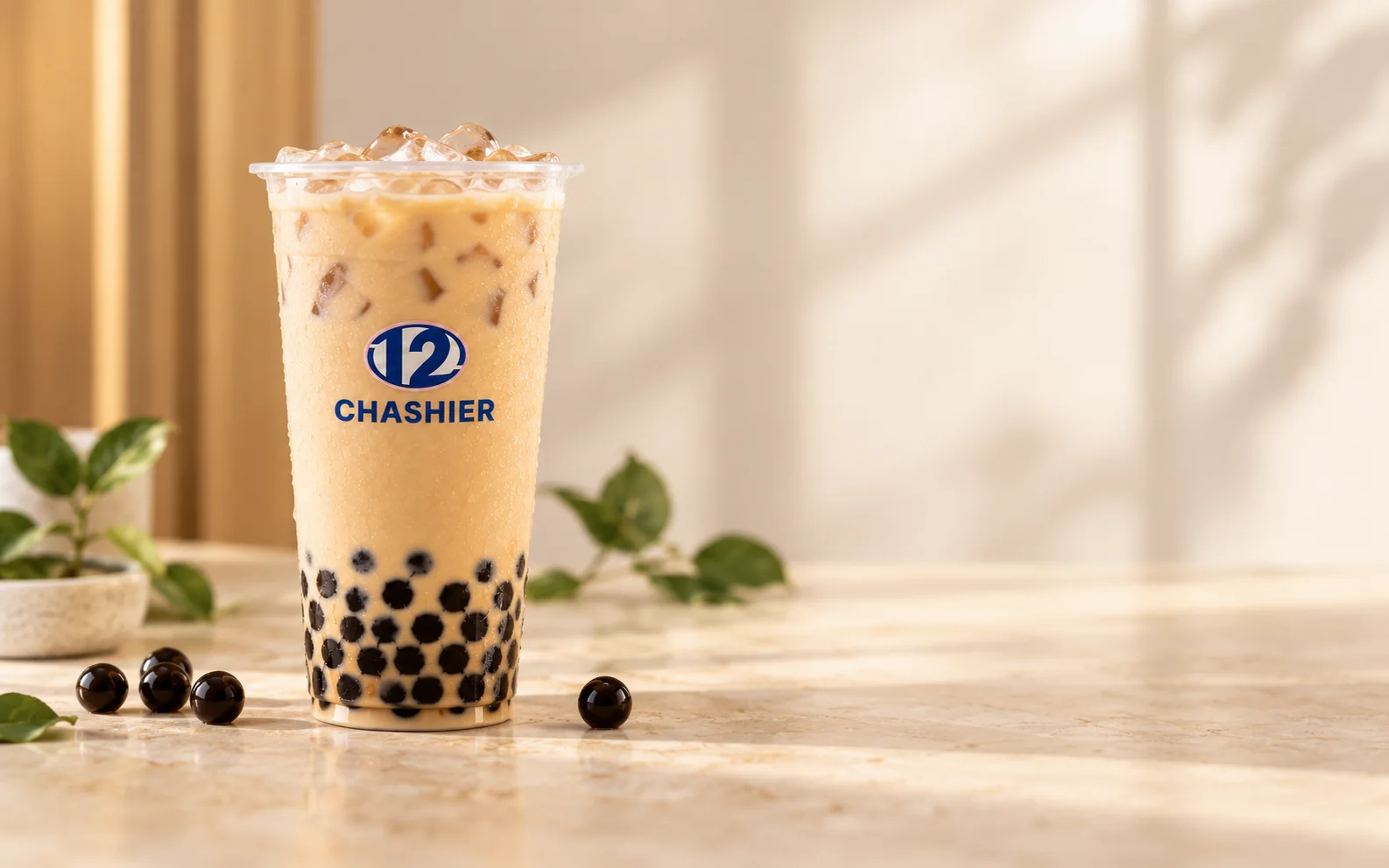 Bubble tea de Chashier, té con leche con perlas de tapioca, sobre un mostrador de mármol con luz natural.